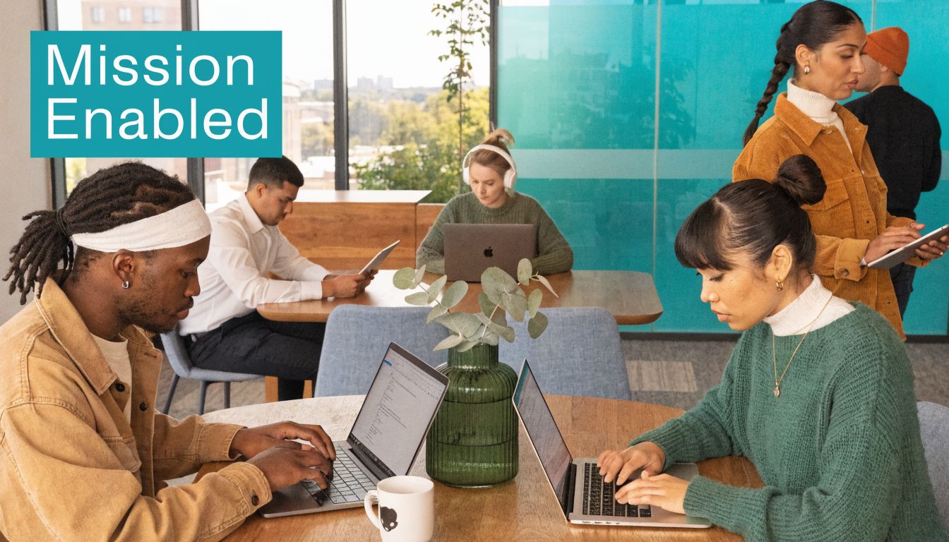 A diverse team of professionals working together in a modern, collaborative open-plan office space.